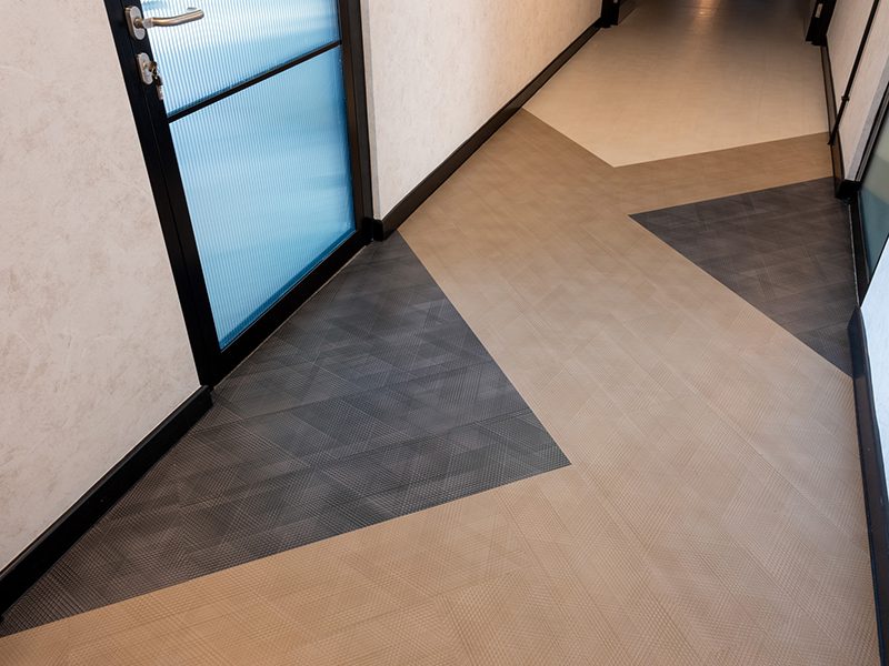 the image shows an example of neuroinclusive workplace design wayfinding patterns incorporated into flooring
