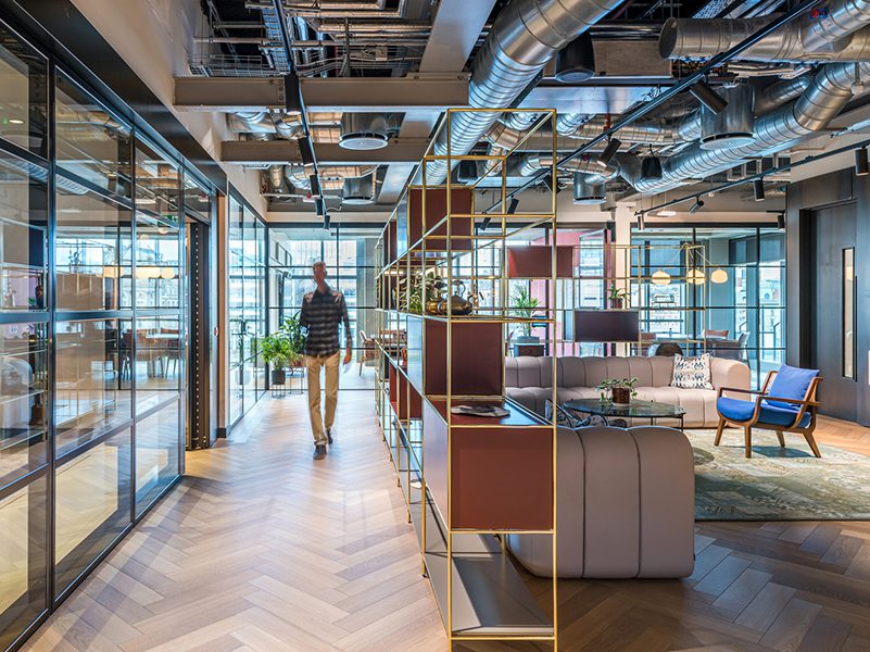 the image shows an example of neuroinclusive workplace design with natural lighting and open spaces